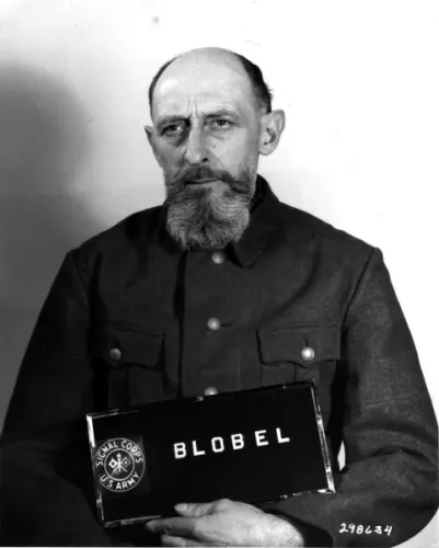 Ein Brustbild von Paul Blobel mit Halbglatze und Vollbart nach seiner Verhaftung.