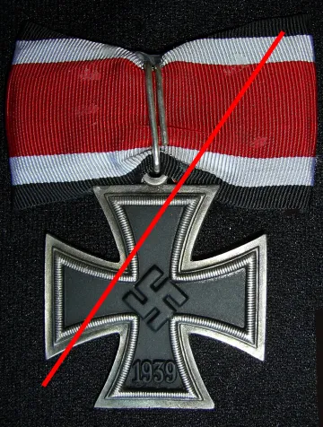 Metallgraues Ritterkreuz mit rotweißem Band, vorsichtshalber mit rotem Querstrich gegen Zweckentfremdung geschützt.