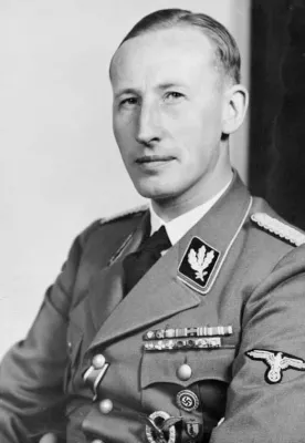 Heydrich mit kurz geschnittenem Haar in Uniform mit Ehrenabzeichen auf der linken Brust, Reichsadler auf dem linken Ärmel und Eisernes Kreuz am Knopfloch.