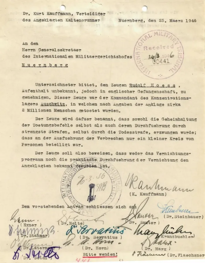 Vergilbtes Dokument mit Schreibmaschinenschrift offiziellen Stempeln. Unter dem Antrag die Unterschriften der Rechtsanwälte.